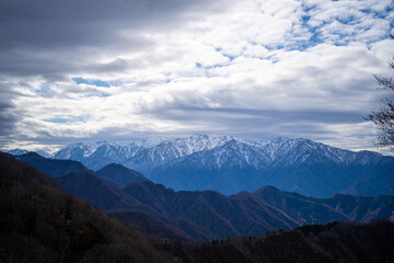 入善町、黒部宇奈月温泉や白馬岳を眺められる富山県入善町の負釣山を紅葉の時期に登山する風景 A view of climbing Mt.Oiturushiyama in Nyuzen-cho, Toyama Prefecture, with views of Kurobe Unazuki Onsen and Mt.Shirouma-dake, during the season of autumn