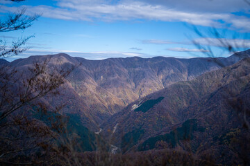 Obraz premium 入善町、黒部宇奈月温泉や白馬岳を眺められる富山県入善町の負釣山を紅葉の時期に登山する風景 A view of climbing Mt.Oiturushiyama in Nyuzen-cho, Toyama Prefecture, with views of Kurobe Unazuki Onsen and Mt.Shirouma-dake, during the season of autumn