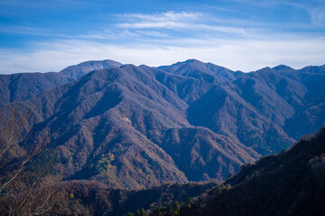 入善町、黒部宇奈月温泉や白馬岳を眺められる富山県入善町の負釣山を紅葉の時期に登山する風景 A view of climbing Mt.Oiturushiyama in Nyuzen-cho, Toyama Prefecture, with views of Kurobe Unazuki Onsen and Mt.Shirouma-dake, during the season of autumn