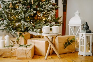 New year 2022, christmas. House room decorated for the holidays. Two cups of tea or coffee on the background of the Christmas tree. Christmas drinks. Warmth and comfort