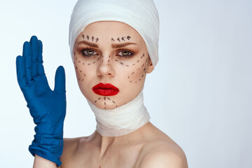 beautiful woman in blue gloves syringe in hands contour on the face lifting light background