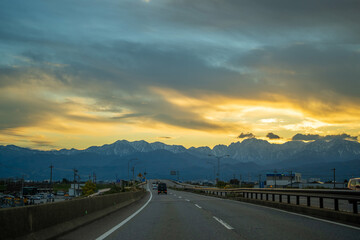 富山県富山市の道路から朝焼けの剱岳や立山を見る風景 View of Tsurugidake and...