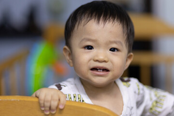 Portrait image of Adorable and happy Chinese baby boy child on baby bed