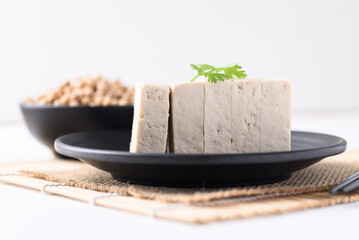 Sliced fresh tofu on black plate with white background, Vegan Food ingredients in Asian food