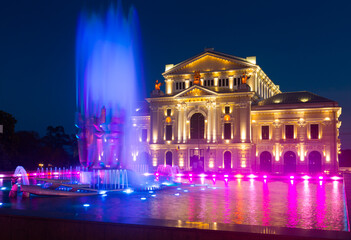 Fototapeta na wymiar Drobeta Turnu-Severin Cultural Palace with colorful lighted fountain at night