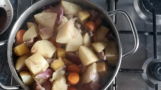 Top Down View Preparation Of Steaming Stirring Stew Pot Cooking On Kitchen Stove