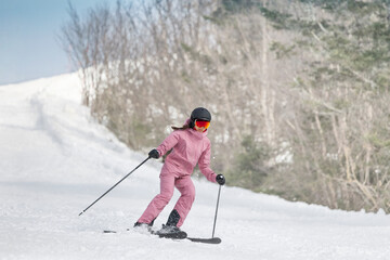 Fototapeta na wymiar Skiing - Woman on ski. Alpine ski concept - skier skiing downhill at mountain snow covered ski trail slopes in winter on perfect powder snow enjoying nature landscape. Elegant pink ski clothing