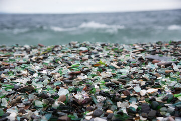 This beach in Vladivostok, Russia is covered with multi-colored glass pebbles. Cloudy day, troubled sea.