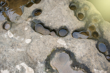 Background image of rocks eroded by river water, grooves and holes. Light fare.