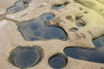 Background image of rocks eroded by river water, grooves and holes. Light fare.