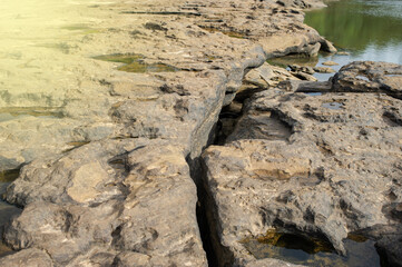 Background image of rocks eroded by river water, grooves and holes. Light fare.