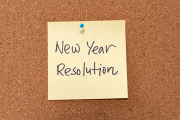 New year resolution yellow note pad on corkboard