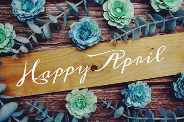 Happy April alphabet letter and flower decorate on wooden background