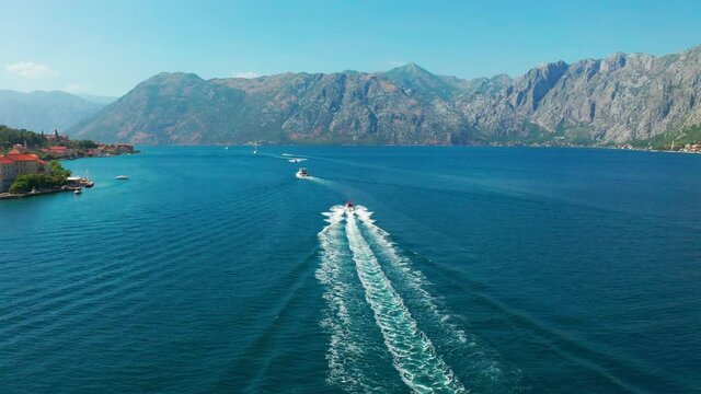 Boat tour on the water bay. Speeding boats on the Kotor Bay in Herceg Novi Montenegro. Aerial drone view 4K.