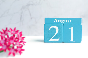 Hello August, Cube wooden calendar showing date on 21 August. Wooden calendar with date on a light background.