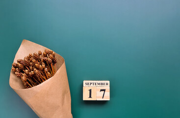 September 17th. Hello September, Cube wooden calendar showing date on 17 September, Wooden calendar with date on a green background.