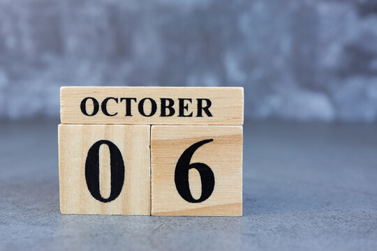 October 6th. Hello October, Cube wooden calendar showing date on 6 October, Wooden calendar with date on a dark background.