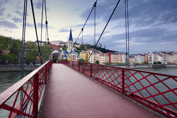 Footbridge and view of old city of Lyon at sunset, France