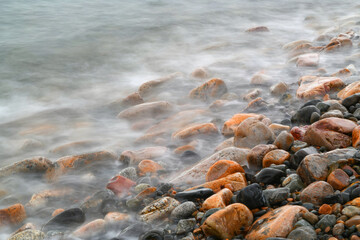 close up on pebble beach with sea wave slow motion