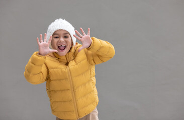 A cute boy smiling in winter coat ready to officially enter winter.
