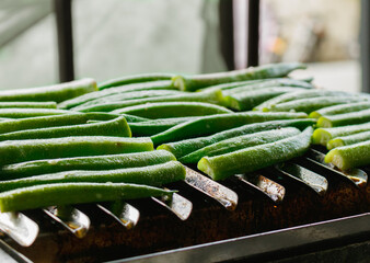 okras getting toasted in a grill