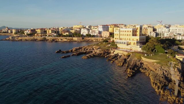 Beautiful aerial shot over the ancient coastal city of Alghero in Italy at sunset