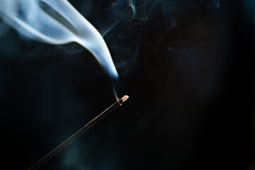smoke from an aromatic stick on a black background.