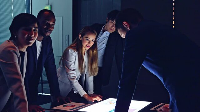 Group of multi racial people watching light screen in the night office. Global business. Teamwork of business. Diversity.