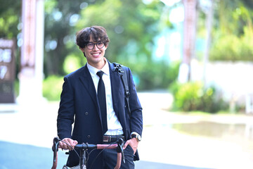 Fototapeta premium Young businessman commuting to work with his bicycle in morning. Eco Transportation and healthy active lifestyle concept.