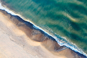 Aerial view of a drone. A bird's eye view of the sea coast. Waves and sandy shore top view.