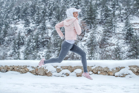 The woman goes in for sports. The girl runs in the winter. High quality photo