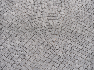 Surface is made of gray paving rock. Paving stones are laid with a turn at right angles. Geometric backdrop concept. Selective focus.
