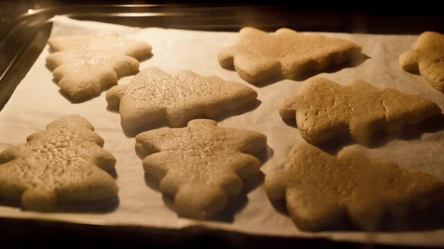 Baking traditional Christmas cookies in kitchen oven. Timelapse with gingerbread biscuits baking