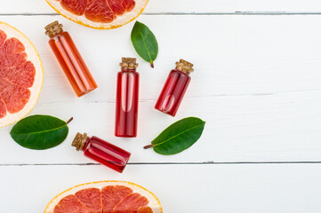 bottles with cosmetics from grapefruit fruits on a white wooden background. flat laying. top view. a copy of the space.