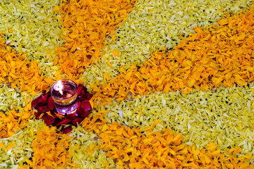 Diya flame on glass of water, flower rangoli design with diya, diwali festival of lights.