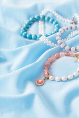bracelets made of natural stones on blue silk fabric