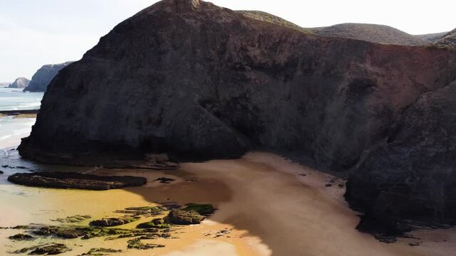 Front drone flight in the volcanic beach of Praia da Barriga, in Algarve, Portugal.