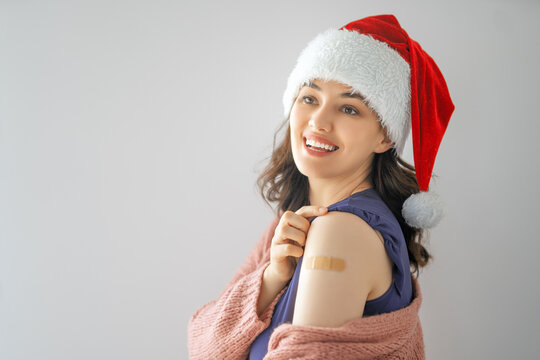 Young woman after vaccination wearing Santa hat