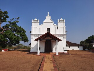 Three Kings church,  goa church, Portuguese church in Goa. blue background with white church. - obrazy, fototapety, plakaty