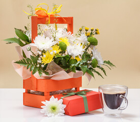 Beautiful bouquet of yellow and white flowers with wooden basket.