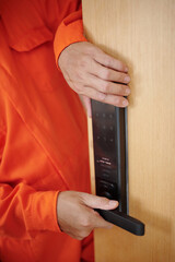 Hands of workman checking of the new smart electronic door lock was installed correctly