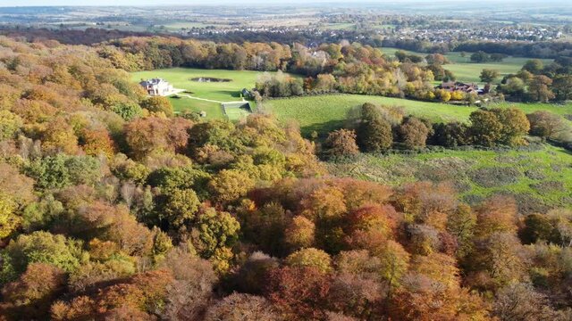 Epping forest England  Theydon Bois in distance  UK in Autumn vibrant tree colours sunny day aerial drone