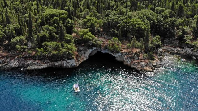 Small Boat Near The Rocky Seacoast With Lush Vegetation In Foki Beach In Kefalonia, Greece. static shot