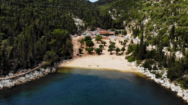 Sandy Foki Beach With Green Forest Covered Hills Near Fiskardo In Kefalonia, Greece. aerial