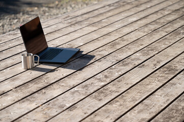 Plakat A computer and coffee on a wooden deck that is easy to use for waking (remote work) and other images.