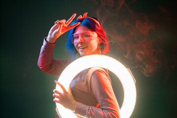 Ring light woman. Blogger illumination. Live stream. Happy smiling futuristic model with peace...