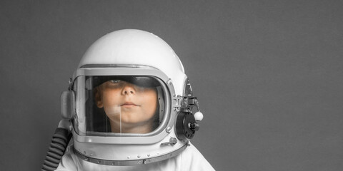 the child studies remotely at school, wearing an astronaut's helmet. back to school