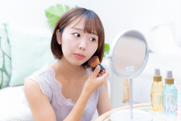 ブラシを使ってメイクをする女性