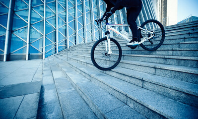 Woman freerider riding bike down city stairs