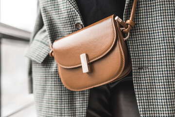 elegant stylish detailed brown handbag in a lady in a beautiful new jacket.